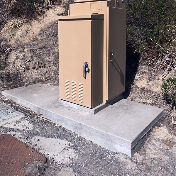 Rural electrical supply box on concrete slab. Vertical.